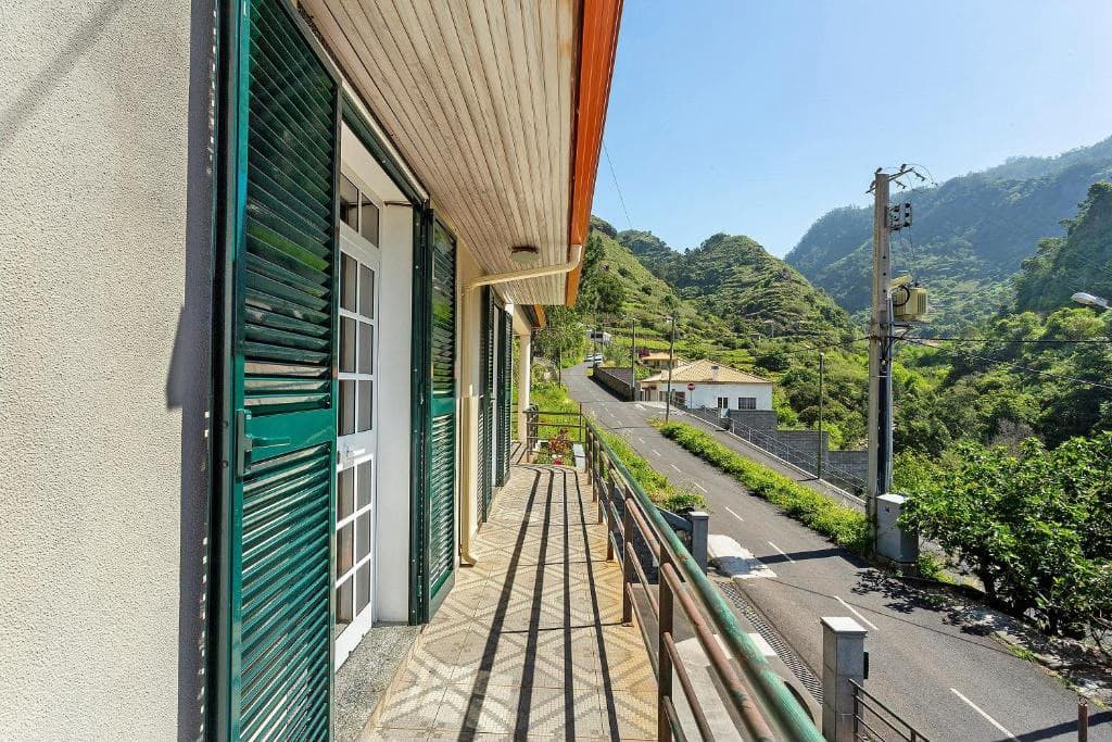 Coursive extérieure aux volets verts surplombant la vallée